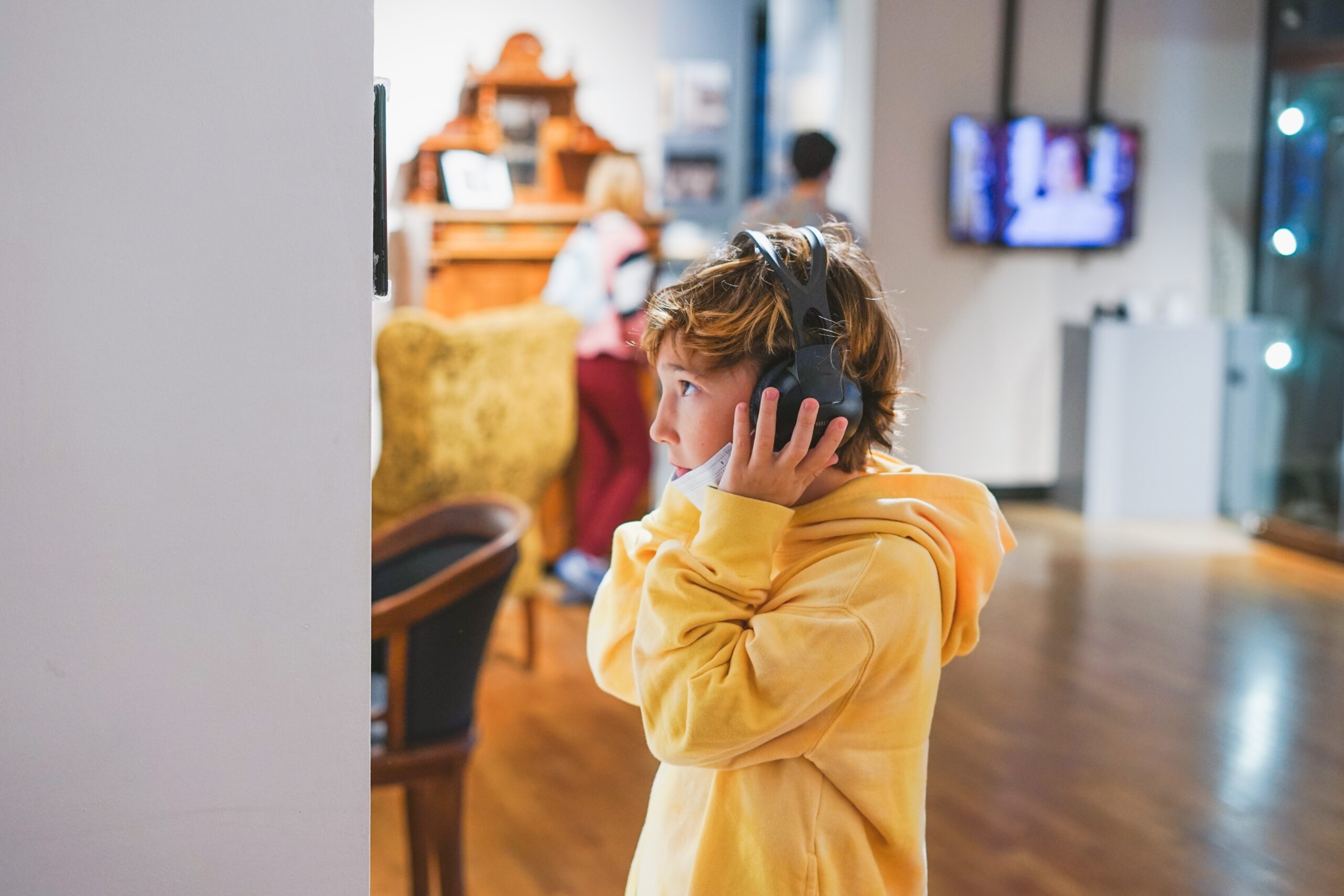 school boy listens to an audio guide at museum